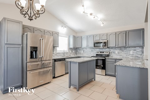 a kitchen with stainless steel appliances and gray cabinets