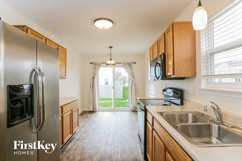 a kitchen with wooden cabinets and stainless steel appliances and a sliding glass door