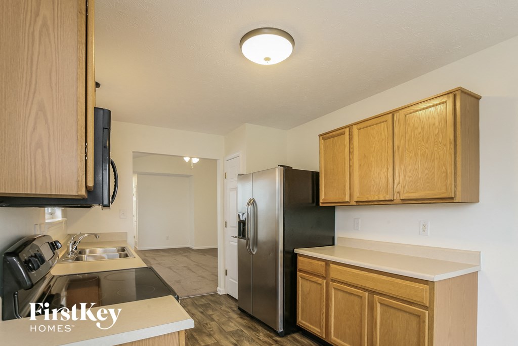 a kitchen with wooden cabinets and a stainless steel refrigerator