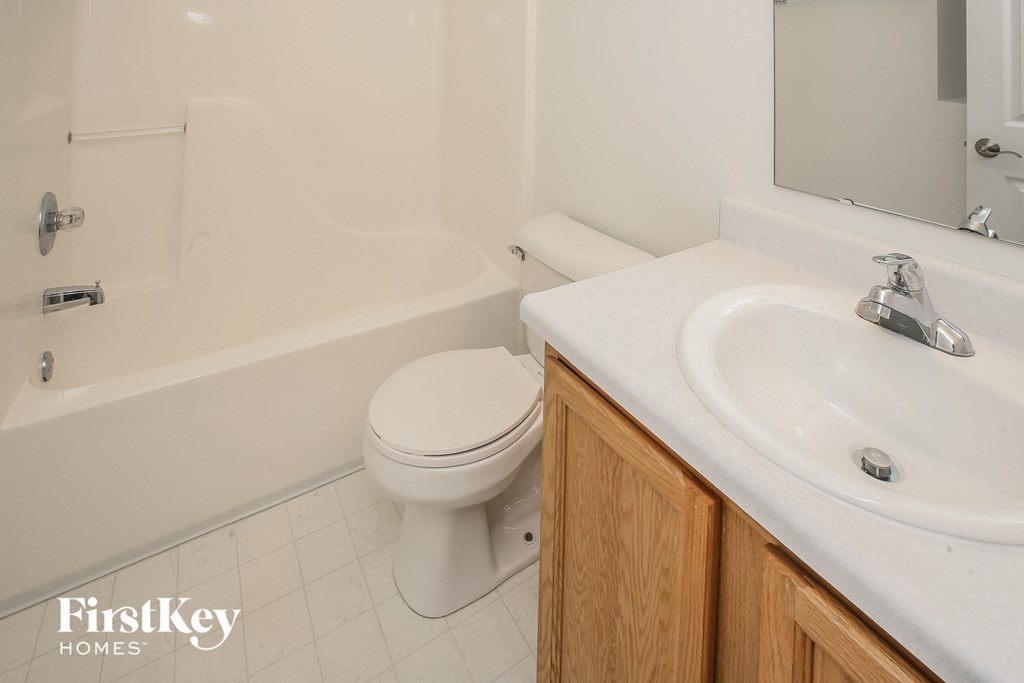 a bathroom with a toilet and a sink and a bath tub