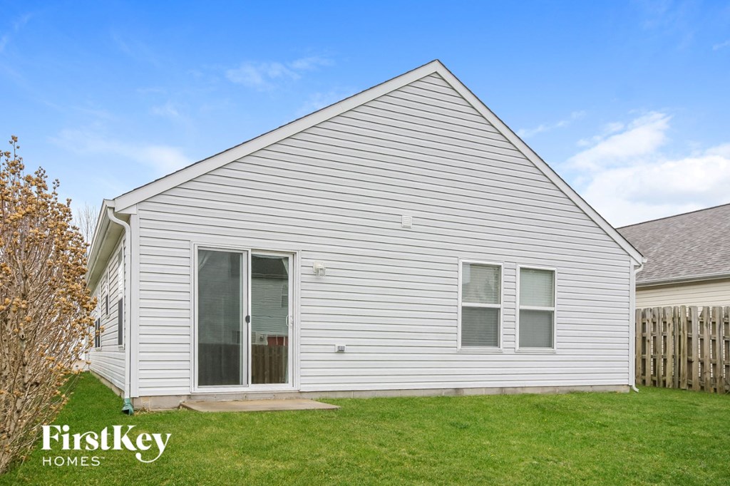 the outside of a white house with white siding and green grass