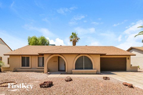 a home with a brown roof and a palm tree