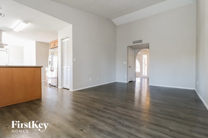 an empty living room with white walls and wood flooring