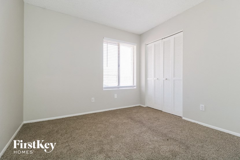 a spacious living room with carpet and a window