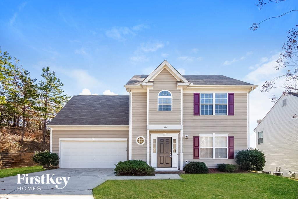 A house with a brown roof and a white garage door is for sale.