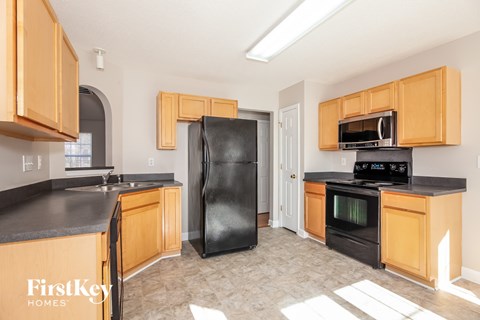A kitchen with wooden cabinets and black appliances.