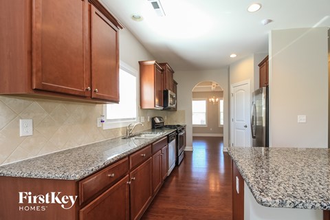 A kitchen with wooden cabinets and granite countertops.