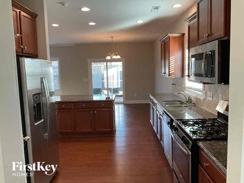 a large kitchen with stainless steel appliances and wooden floors