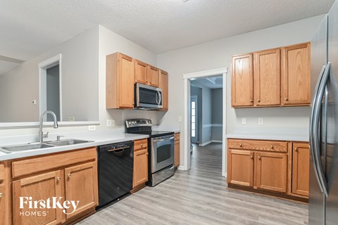 a kitchen with wooden cabinets and black appliances and a sink