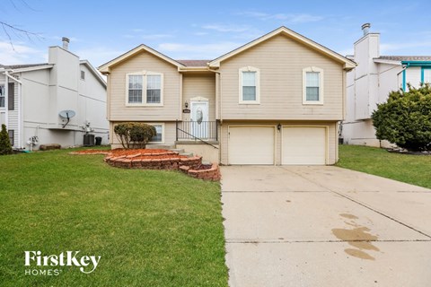 the front of a house with a sidewalk and grass