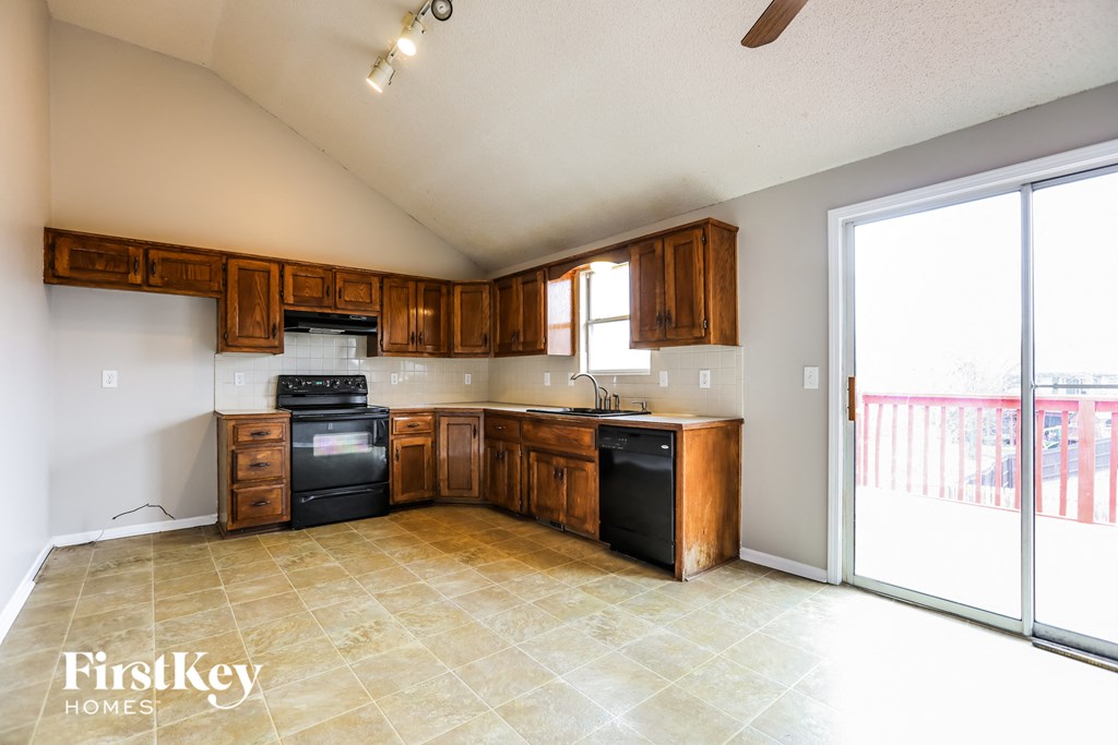 an empty kitchen with wooden cabinets and a sliding glass door