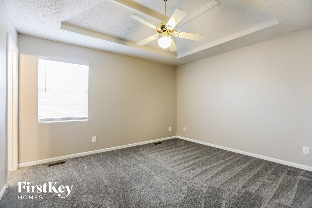a bedroom with carpet and a ceiling fan
