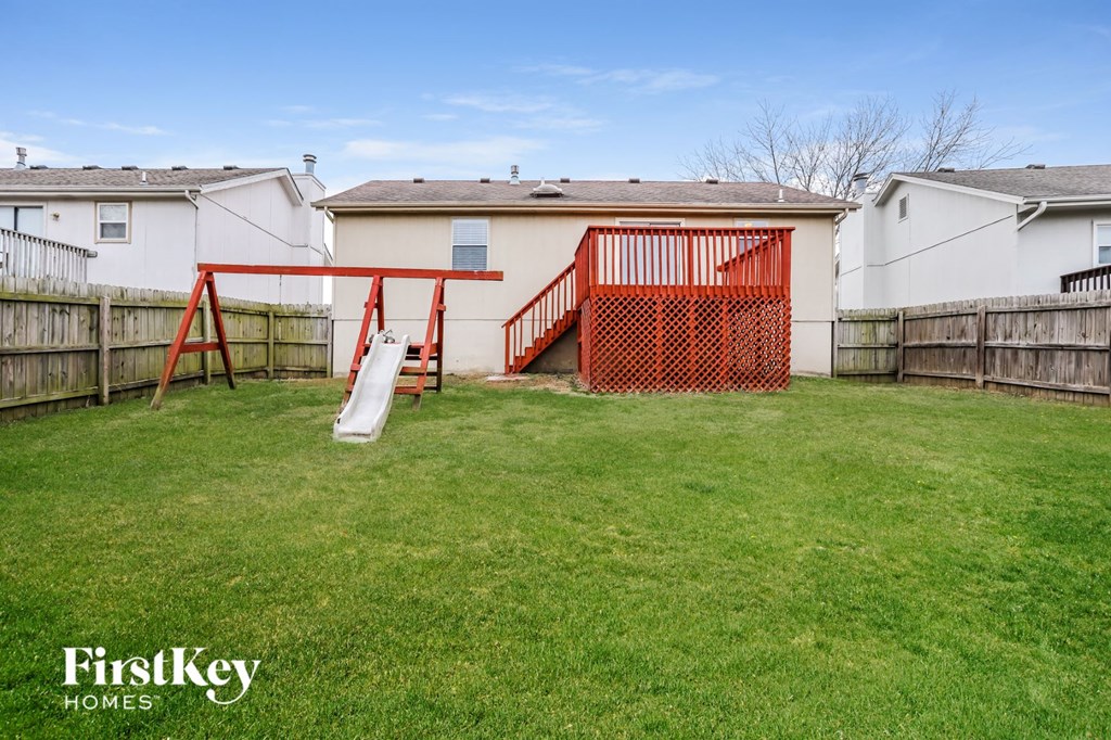 a backyard with a swing set and a slide