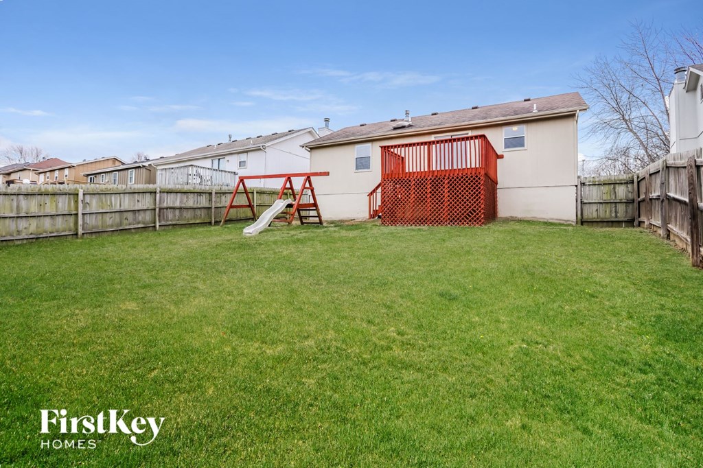 a backyard with a swing set and a fence