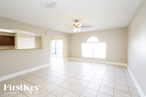 A spacious room with a ceiling fan and tiled flooring.