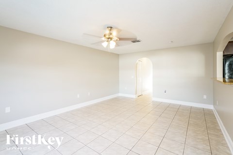 A spacious room with a ceiling fan and tiled floor.