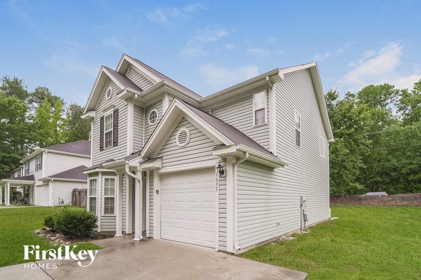 a white house with white siding and a driveway