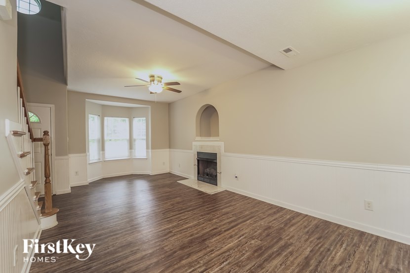 a living room with a fireplace and a ceiling fan