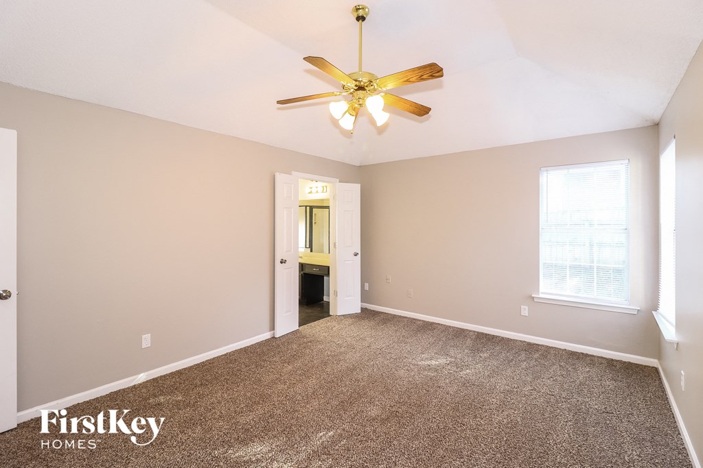 a living room with carpet and a ceiling fan
