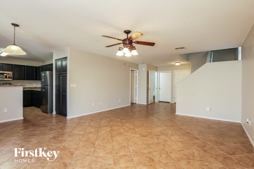 an empty kitchen and living room with a ceiling fan