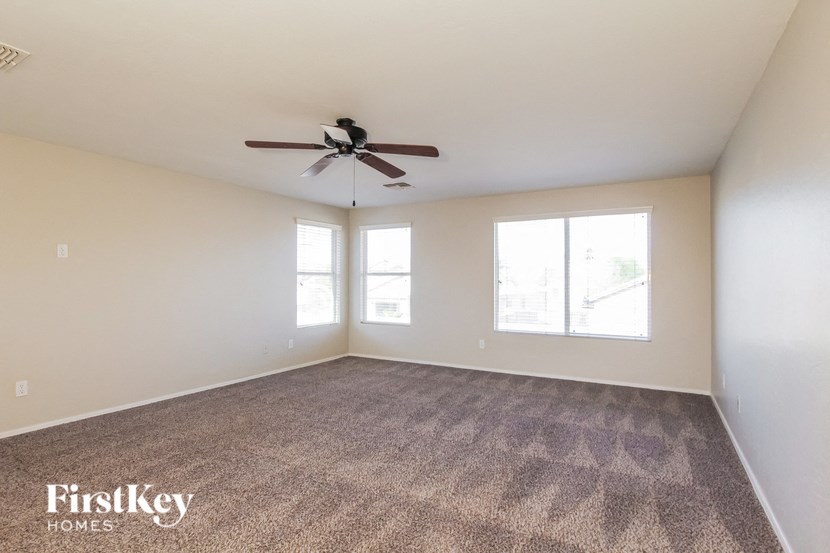 a living room with carpet and a ceiling fan