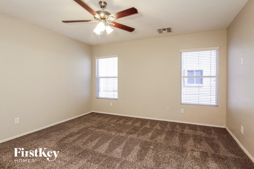the spacious living room with carpeting and a ceiling fan