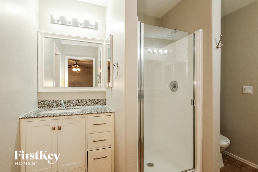 a bathroom with a shower and a sink and a mirror
