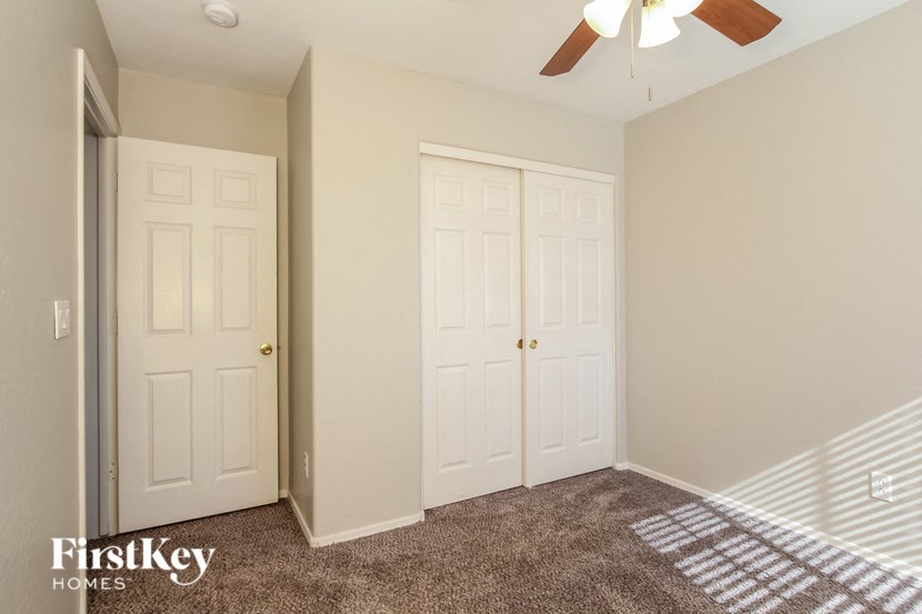 a bedroom with two closets and a bed and a ceiling fan