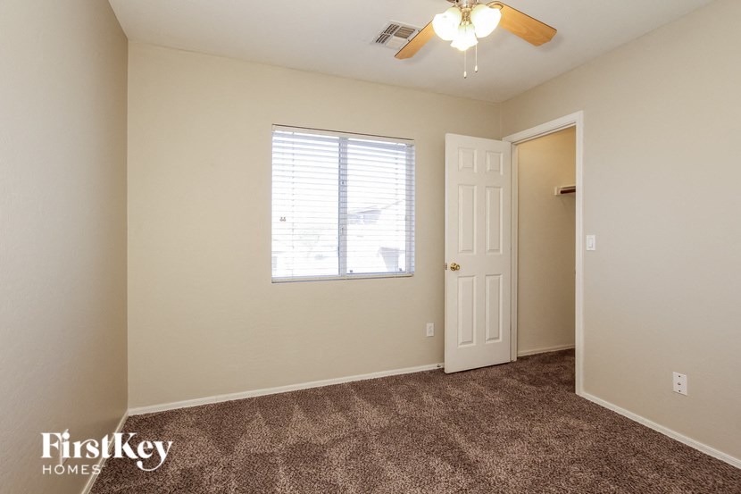 a bedroom with carpeted flooring and a ceiling fan