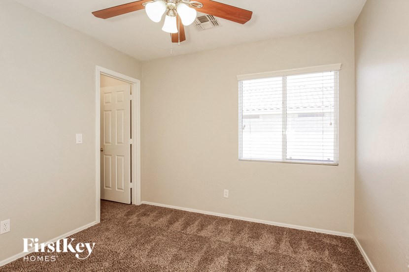 a bedroom with carpet and a ceiling fan