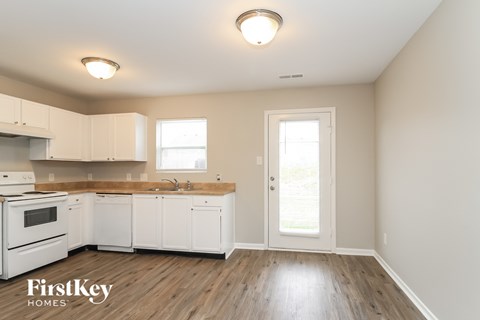 A kitchen with white cabinets and a wooden countertop.