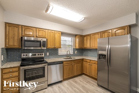 an image of a kitchen with stainless steel appliances and wooden cabinets