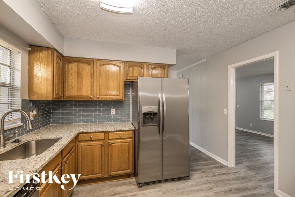 a kitchen with wooden cabinets and a stainless steel refrigerator