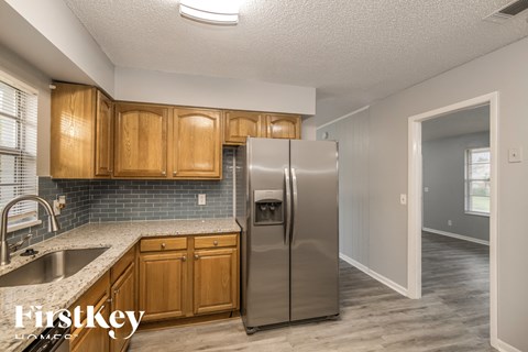 a kitchen with wooden cabinets and a stainless steel refrigerator