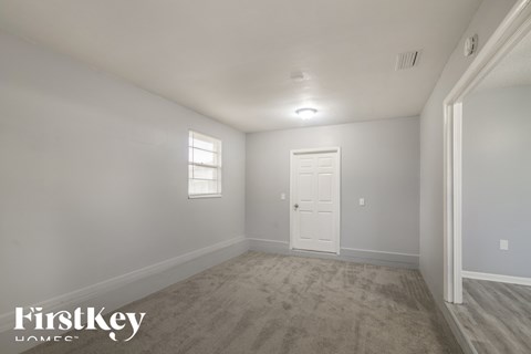 a empty room with a white door and a window