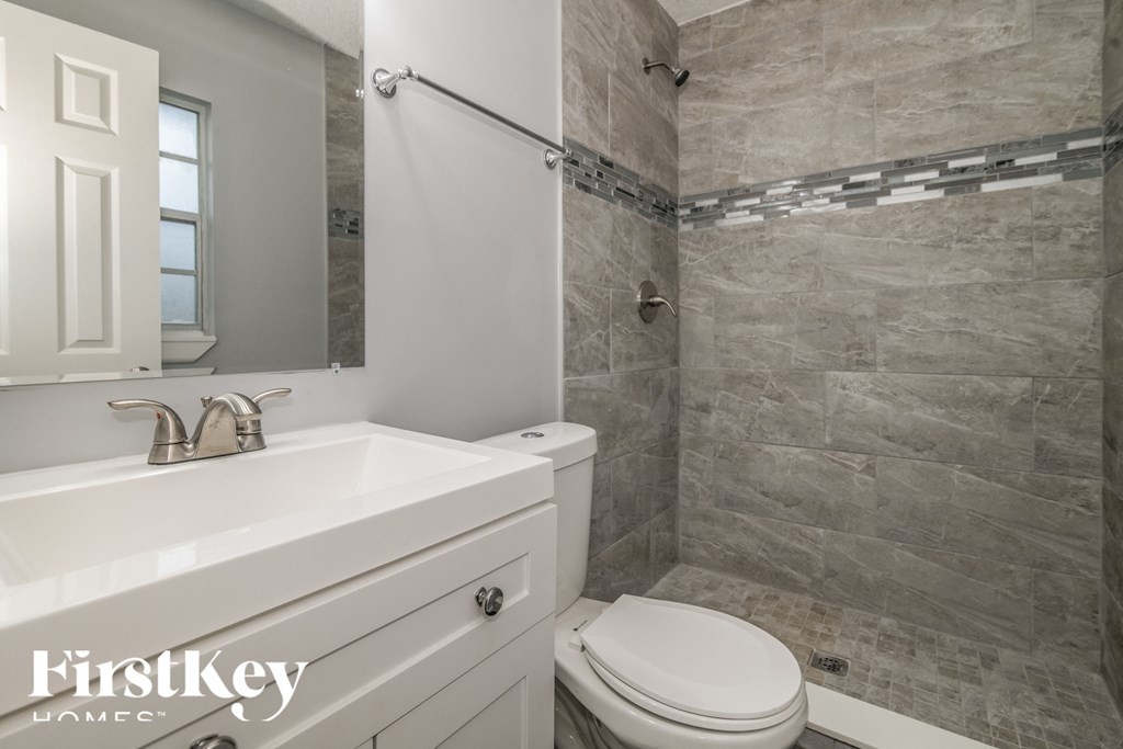 a bathroom with a toilet and a sink and a shower