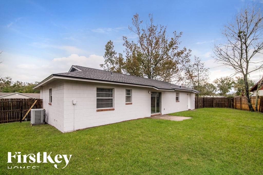 a small white house in a backyard with a grassy yard