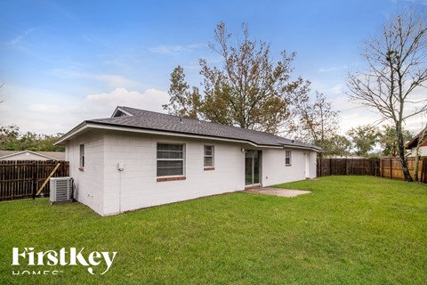 a small white house in a backyard with a grassy yard