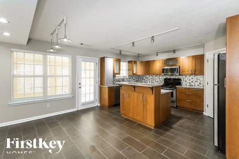 A kitchen with wooden cabinets and a tile floor.