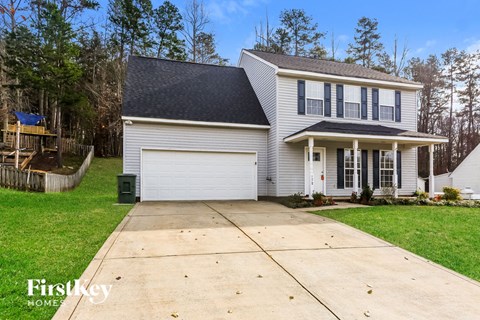 A house with a garage and a driveway in front of it.