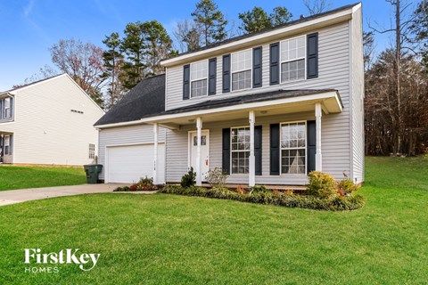 A house with a grey siding and a black roof is for sale by FirstKey Homes.