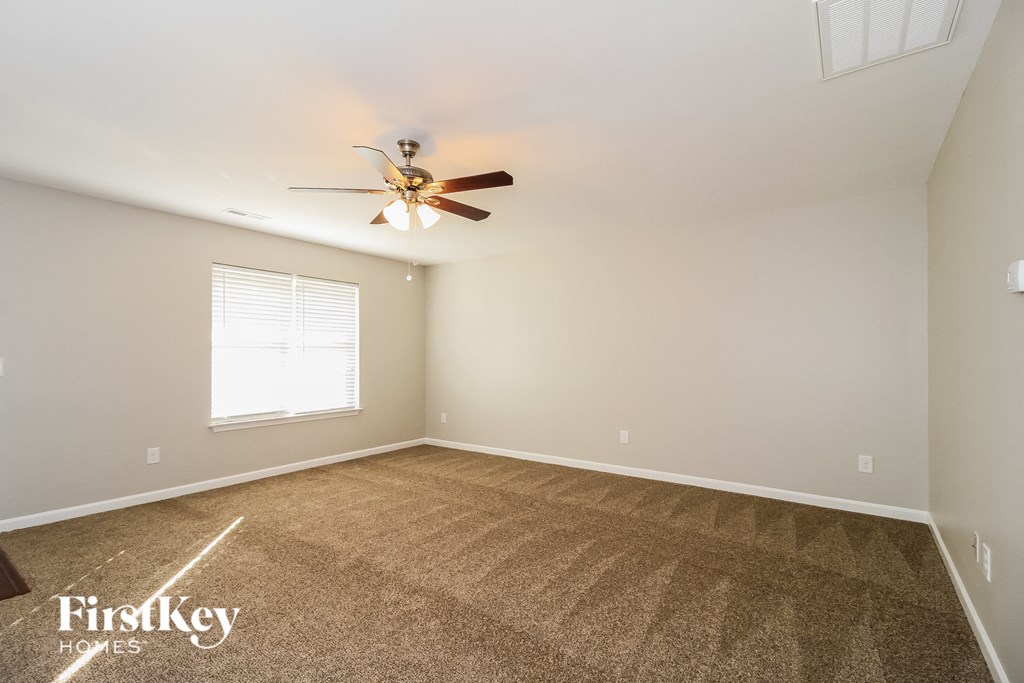 a bedroom with carpet and a ceiling fan