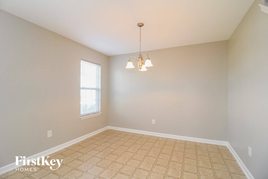an empty dining room with tiled floors and a window