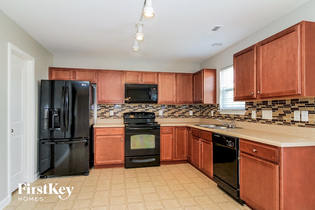 a kitchen with black appliances and wooden cabinets