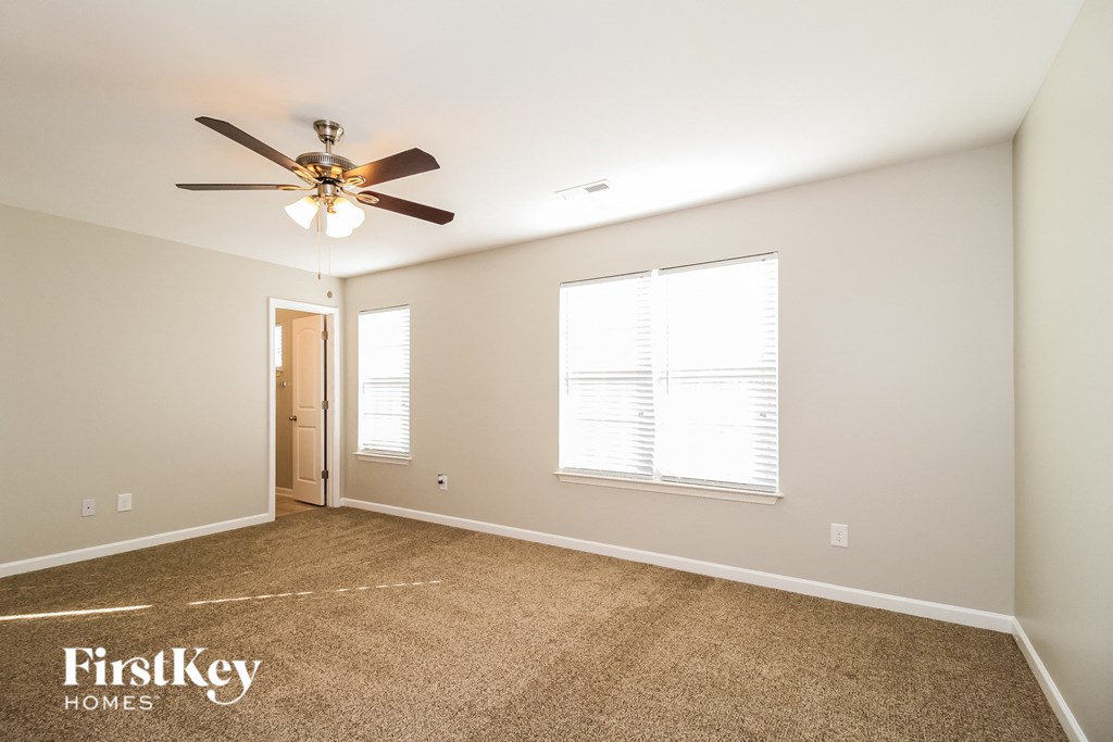 an empty room with a ceiling fan and a window
