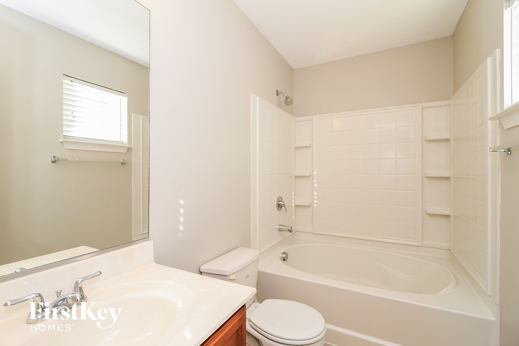 a white bathroom with a tub and a sink and a toilet