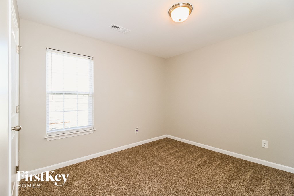 a bedroom with a carpeted floor and a window