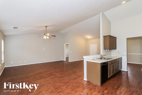 A kitchen area with a wooden floor and a white ceiling.