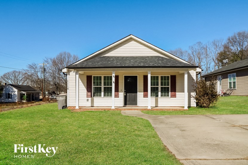 a small white house with a front porch and a black door