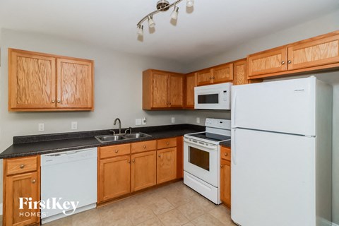 a kitchen with white appliances and wooden cabinets